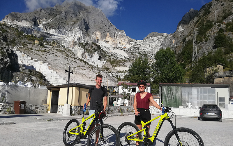 two people by ebike in the carrara marble valleys