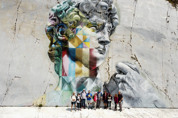 camminatori davanti al murale di kobra, cave di marmo di carrara