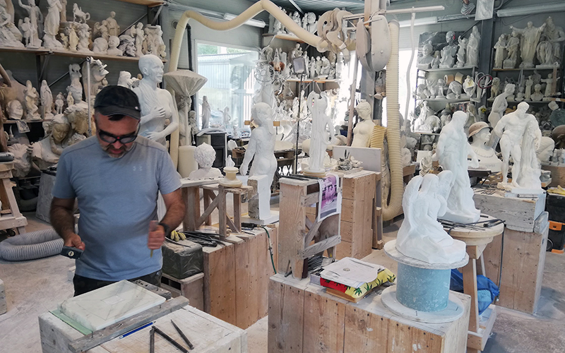 carrara, tourist carving marble during the sculpting class