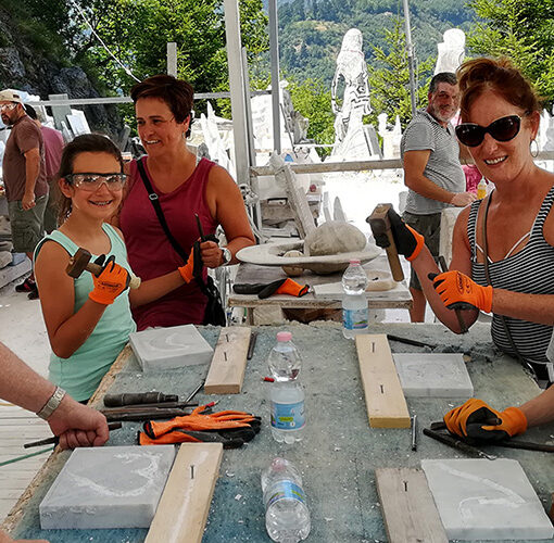 family with kids having fun carving marble