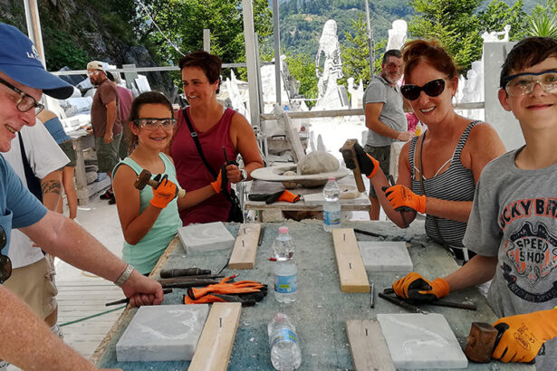 family with kids having fun carving marble