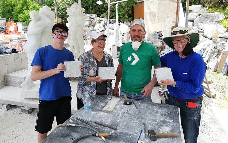 family proudly show their marble works after the class