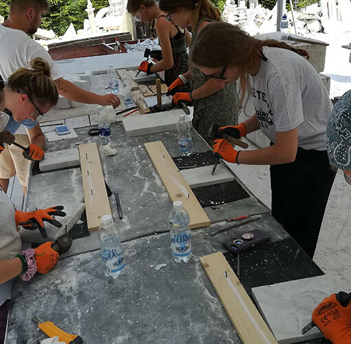 ragazze al lavoro per scolpire il mare a carrara