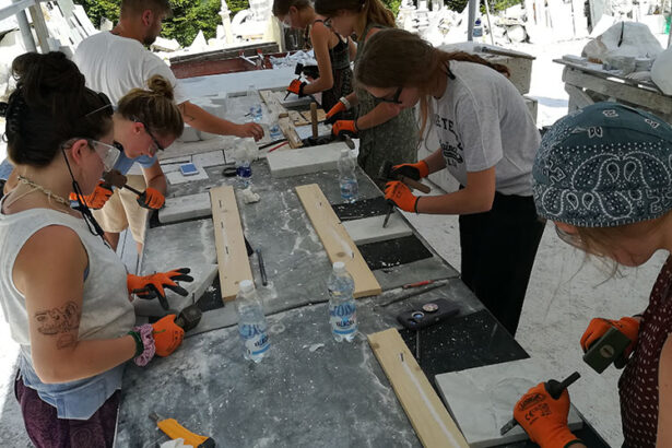 ragazze al lavoro per scolpire il mare a carrara