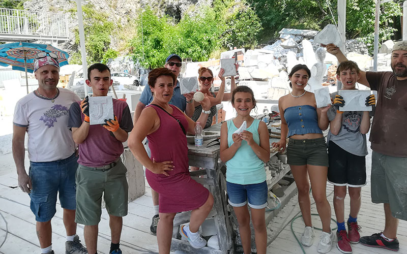 carrara, turisti mostrano i loro lavori in marmo dopo lezione di scultura