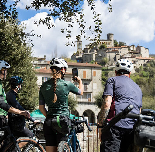 people by bike with bagnone village in the background