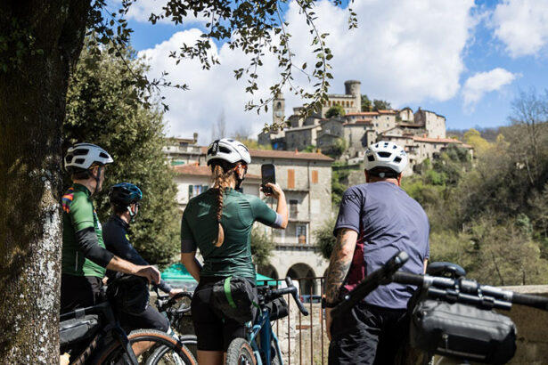 people by bike with bagnone village in the background