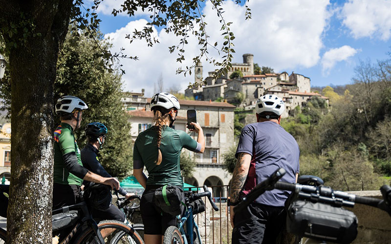 people by bike with bagnone village in the background