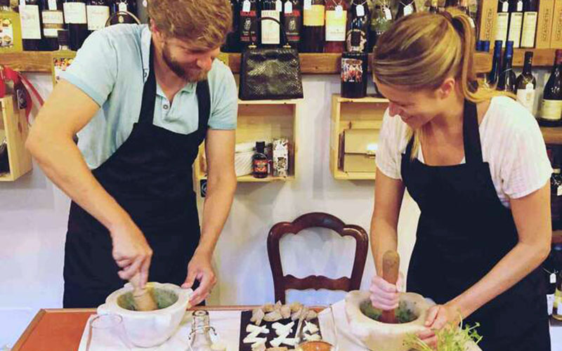 Two people making pesto by hands